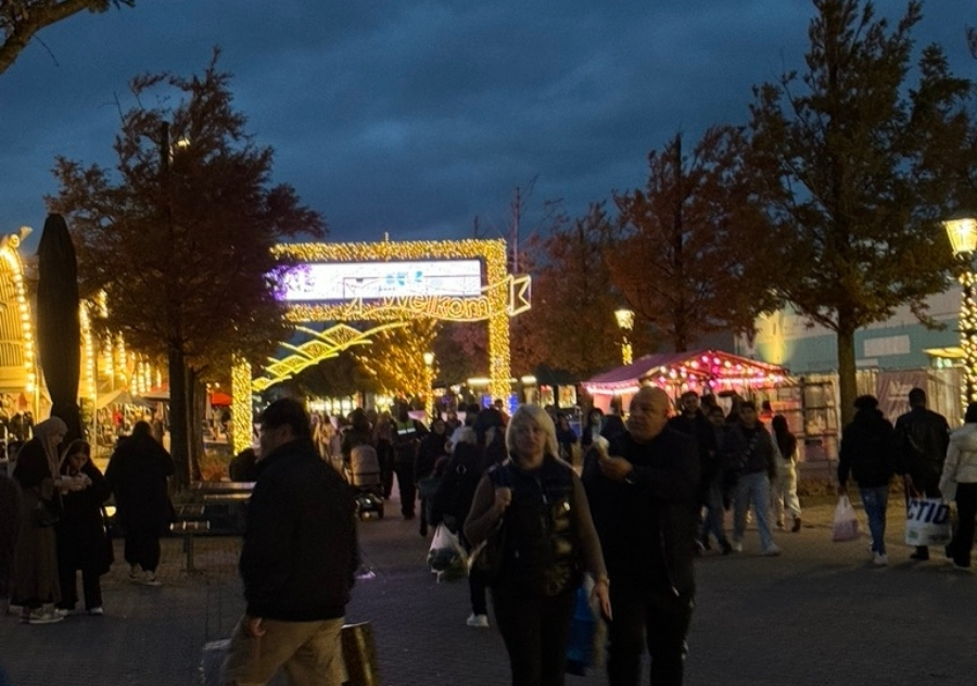 Bezoekers lopen tijdens de schemering over een feestelijk verlichtte Boulevard